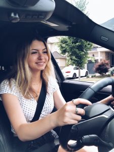 Happy young teenage girl is smiling while taking her first driving lessons